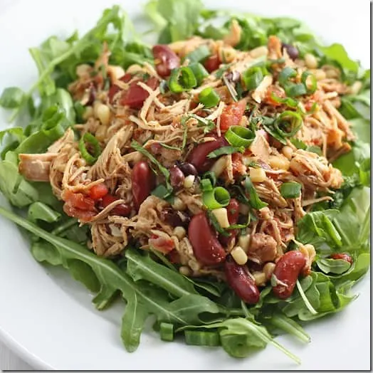 White plate with Slow Cooker Chicken Burrito Bowl over lettuce