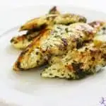 Grilled chicken breast strips on white plate